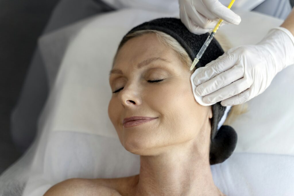 Senior woman relaxing during facial mesotherapy for smoothing of mimic wrinkles