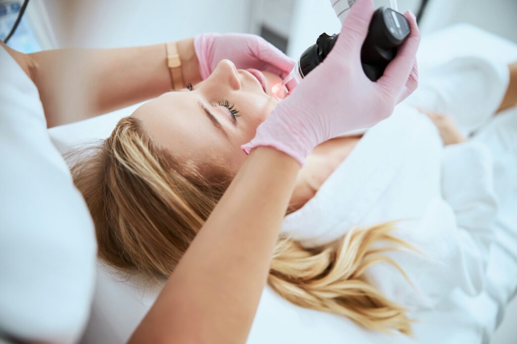 Woman receiving the fractional laser treatment in a beauty salon